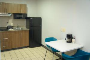 a kitchen with a table and chairs and a refrigerator at Studio 6-West Palm Beach, FL in West Palm Beach