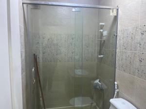 a bathroom with a glass shower with a toilet at Monte cairo Pool View in Cairo