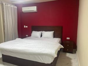 a bedroom with a bed with a red wall at Monte cairo Pool View in Cairo