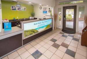 a waiting room at a dental office with a large tv at Studio 6-Coral Springs, FL - Fort Lauderdale in Coral Springs