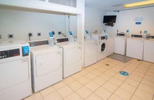 a laundry room with washing machines and a tv at Studio 6-Coral Springs, FL - Fort Lauderdale in Coral Springs