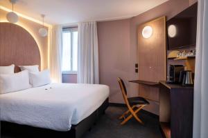 a hotel room with a bed and a chair at Best Western Bretagne Montparnasse in Paris