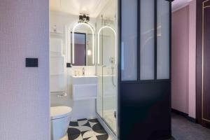ein Badezimmer mit Dusche, Toilette und Waschbecken in der Unterkunft Best Western Bretagne Montparnasse in Paris