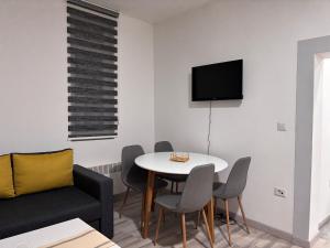 a living room with a table and a couch at Apartment Grey Deluxe in Sarajevo