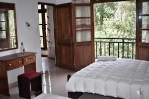 une chambre avec un grand lit et un balcon dans l'établissement Rock View Home, à Kandy