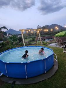 two people swimming in a large blue hot tub at Casa Oma Loni in Pomerode