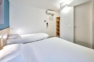 ナルボンヌにあるKyriad Direct Narbonne Sudのベッド2台とクローゼットが備わる客室です。