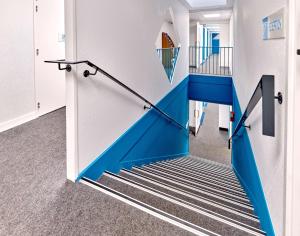 eine blaue Treppe in einem Zimmer mit Treppenaufgang in der Unterkunft Kyriad Direct Narbonne Sud in Narbonne