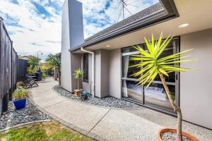 uma casa com uma palmeira num pátio em Stunning Family Home em Auckland