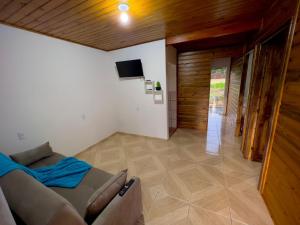 een woonkamer met een bank en een televisie bij Casa Jardinada in Pomerode