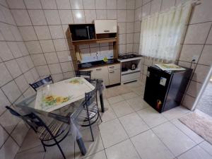 a small kitchen with a table and chairs in it at Casa Jardinada in Pomerode
