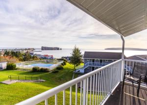 uitzicht op het water vanaf het balkon van een huis bij Hôtel le Mirage in Perce