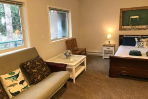 ClintonにあるThe Quintessa Cottageのベッドルーム1室(ベッド1台、ソファ、テーブル付)