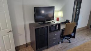 a room with a desk with a television on a dresser at Quality Inn Forsyth near GA Public Safety Training Center in Forsyth