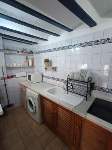 uma cozinha com um lavatório e uma máquina de lavar roupa em La Casita em Úbeda
