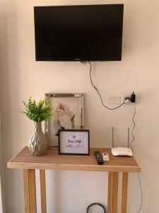 a shelf with a television and a picture and a phone at Acogedor apartamento en Canning in Canning