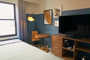 a bedroom with a bed and a desk with a television at Hotel Julian in San Francisco