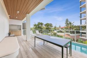 a living room with a table and a pool at Bianca By The Beach is Paradise! in Gold Coast
