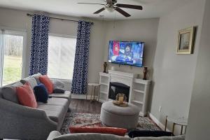 ein Wohnzimmer mit einem Sofa, einem TV und einem Kamin in der Unterkunft Charming & Spacious 3BR House in Concord