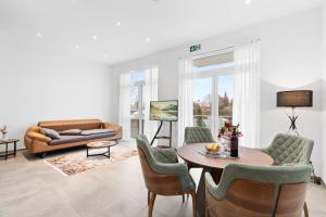 a living room with a table and chairs and a couch at Premium SmartApart mit Smarthome zentral modern 24h-check-in in Tettnang