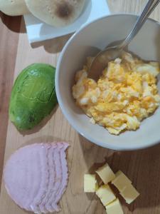 uma tigela de ovos mexidos e queijo numa mesa em Verdeagua Hostal em Chaitén