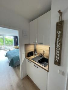 eine Küche mit einem Waschbecken und ein Bett in einem Zimmer in der Unterkunft Haus Vier Jahreszeiten am See Vier Jahreszeiten - HS 221 in Goslar