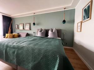 ein Schlafzimmer mit einem Bett mit einer grünen Bettdecke in der Unterkunft Haus Vier Jahreszeiten am See Vier Jahreszeiten - HS 221 in Goslar