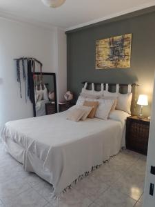 1 dormitorio con 1 cama grande con sábanas y almohadas blancas en Departamento Alvear 388 en Salta