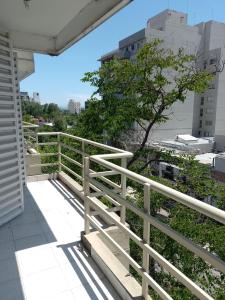 un balcón con una valla blanca y un árbol en Departamento Alvear 388 en Salta