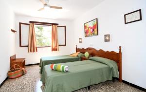 una camera con due letti verdi e una finestra di Hostal La Ceiba a Cala d´Or