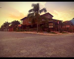 a building with a palm tree on the side of a street at Residencial Banzaê in Garopaba