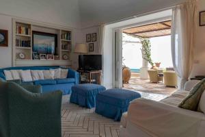 sala de estar con sofá azul y sillas en Beautiful Villa with View in the heart of Capri, en Capri