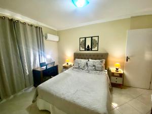 um quarto com uma cama, 2 candeeiros e uma janela em Top Ap 3 Qts a 3 quadras da orla Sua família sem aperto Não sofra férias, desfrute-as em Aracaju