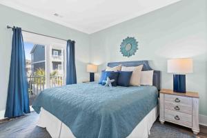 a bedroom with a blue bed and a window at Beers and Sunshine Ocean Isle Beach, Heated pool, elevator, across from beach access in Ocean Isle Beach +65 photos