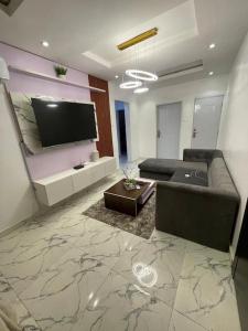 sala de estar con sofá y TV de pantalla plana en Deemich Maison 2bed apartment. en Lagos