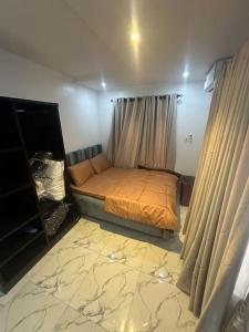 a bedroom with a bed in a room with curtains at Deemich Maison 2bed apartment. in Lagos