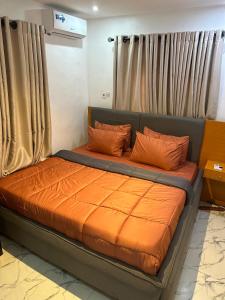 uma cama com almofadas laranja num quarto em Deemich Maison 2bed apartment. em Lagos