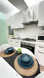 een keuken met een tafel met blauwe platen bij Lætitia Cottage Apartment in Aversa