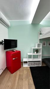 een kamer met een rode koelkast en een bed bij Lætitia Cottage Apartment in Aversa