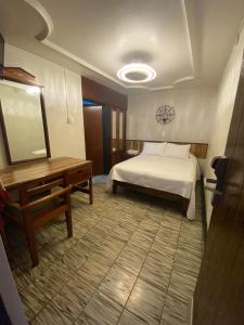 1 dormitorio con cama, mesa y espejo en HOTEL FLAMINGOS DE CIUDAD GUZMAN, en Ciudad Guzmán