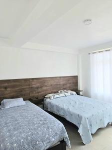 a bedroom with two beds and a window at Casa de Playa Luxury Laguna Azul Tacna in Tacna