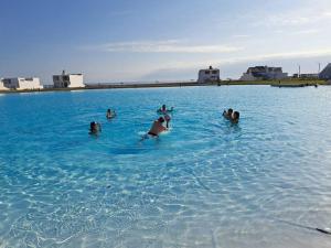 a group of people swimming in a large body of water at Casa de Playa Luxury Laguna Azul Tacna in Tacna