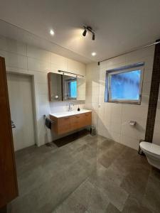 ein Bad mit einem Waschbecken und einem WC in der Unterkunft Ferienhaus am Glück in Bad Zwischenahn