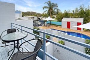 balcón con mesa, sillas y piscina en 3-Bed with Alfresco Dining & Pool in Batemans Bay, en Batemans Bay