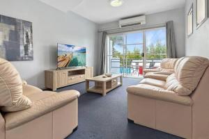 Sala de estar con 2 sofás y mesa en 3-Bed with Alfresco Dining & Pool in Batemans Bay, en Batemans Bay