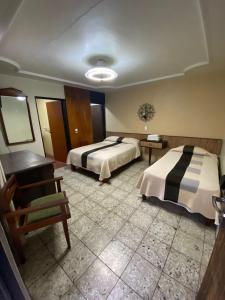 Habitación de hotel con 2 camas y escritorio en HOTEL FLAMINGOS DE CIUDAD GUZMAN, en Ciudad Guzmán