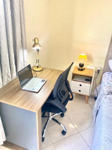 a desk with a laptop and a chair in a bedroom at Top Ap 3 Qts a 3 quadras da orla Sua família sem aperto Não sofra férias, desfrute-as in Aracaju