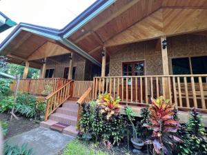 a house with a wooden porch and stairs to it at Ozar Homestay in Mambajao