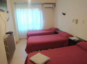 Zimmer mit 3 Betten und einem Fenster in der Unterkunft Hotel Manzanares Plaza in Buenos Aires
