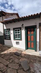 a house with a green and red door and windows at Casa histórica do escravo isidoro in Diamantina